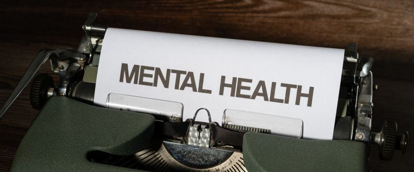 Close-up of a vintage typewriter displaying a mental health message on paper.