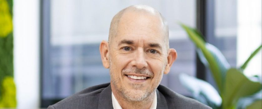 Andy Schachtel, founder and CEO of Sourcefit, seated in a grey suit with his hands clasped