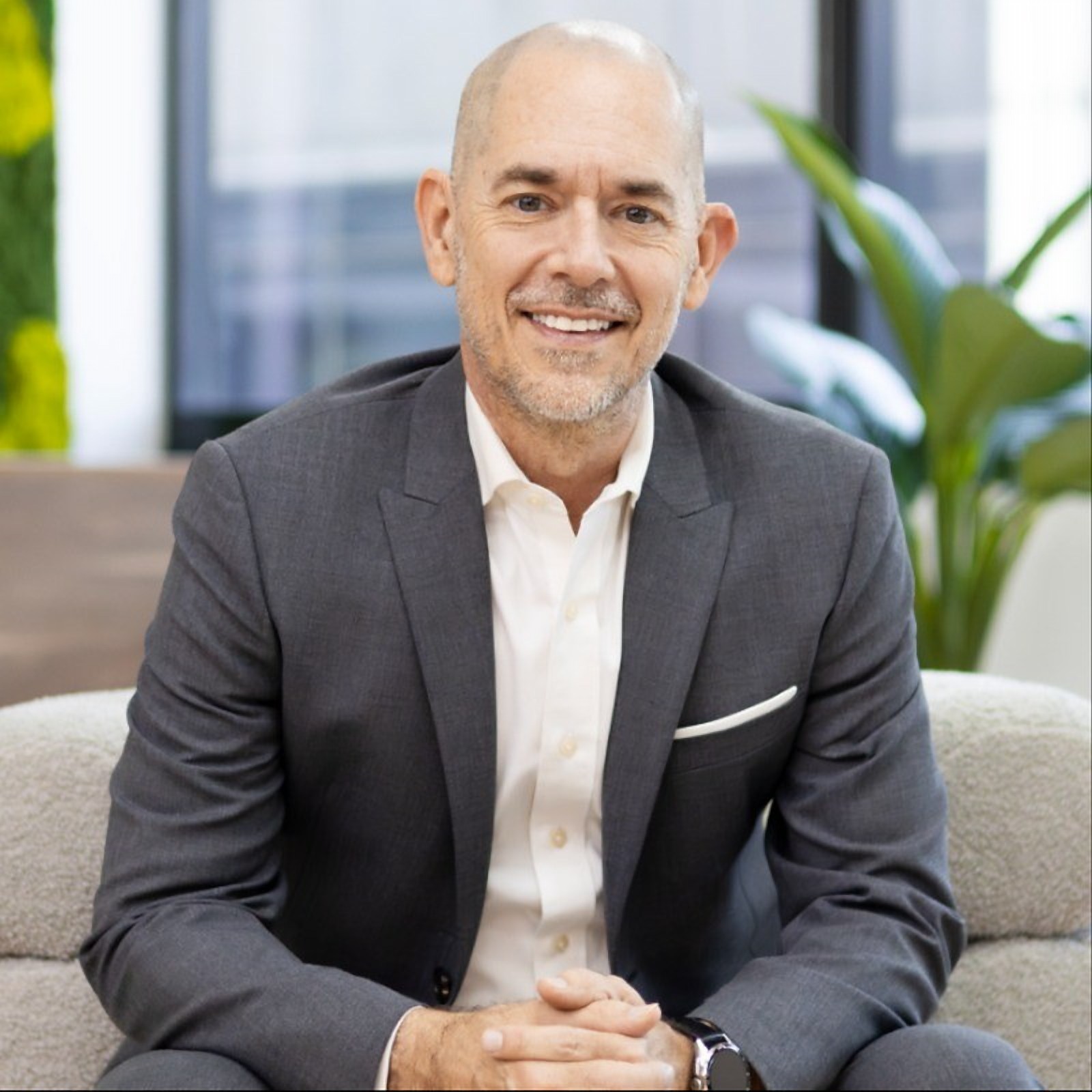 Andy Schachtel, founder and CEO of Sourcefit, seated in a grey suit with his hands clasped