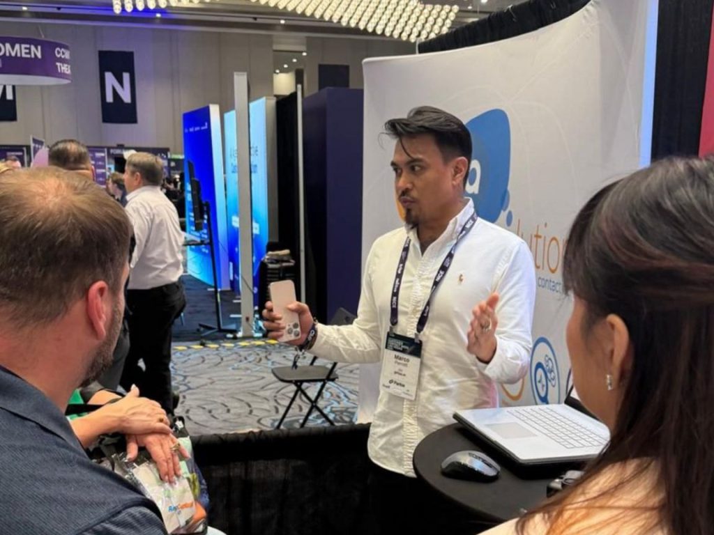 Marco Perrott talking with visitors at an expo booth