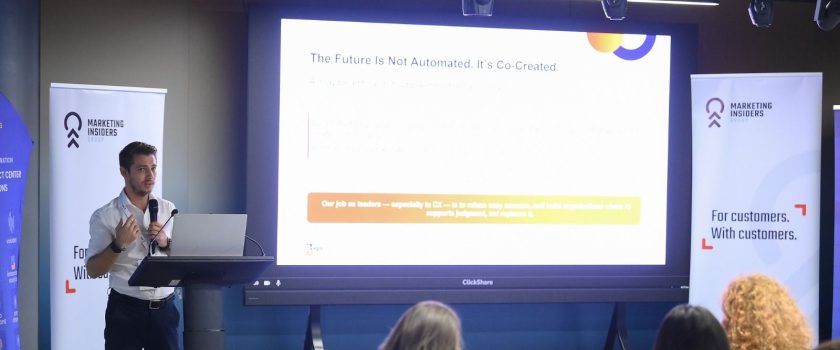 Alin Roșca speaking at a podium beside a slide headed The Future Is Not Automated. It